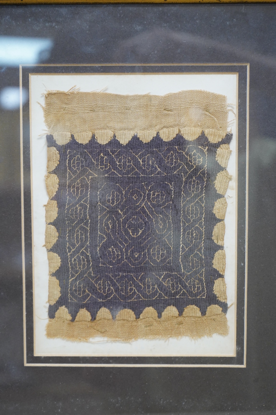 A framed Coptic textile fragment, probably Egyptian, circa 7th century A.D. (Please see notes on reverse), 16cm x 12cm. Condition - good